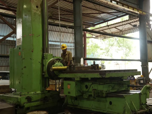 Worker beside a horizontal machine tool in the workshop.