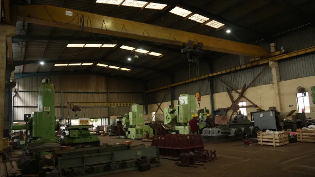 Wide view of workshop machines and workers.